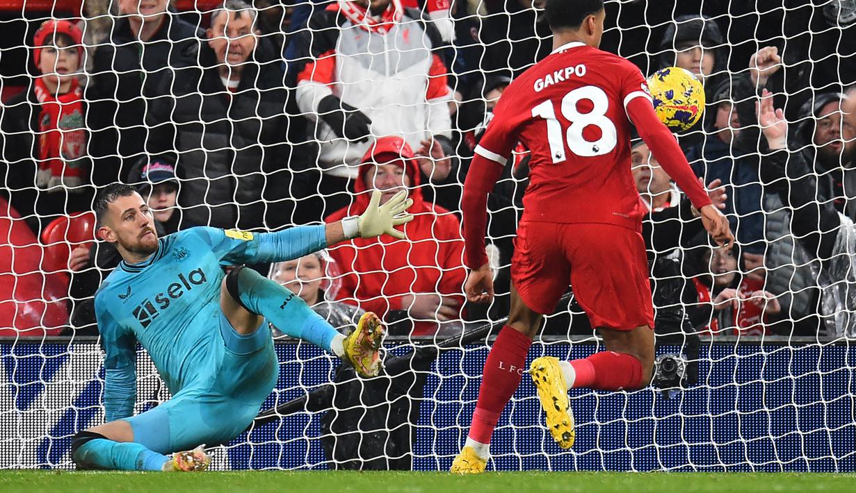 Kiper Newcastle United, Martin Dubravka (kiri) gagal menghalau bola tendangan pemain Liverpool, Cody Gakpo pada laga lanjutan Liga Inggris 2023/2024 di Anfield, Liverpool, Inggris, Selasa (02/01/2024) dini hari WIB. (AFP/Peter Powell)