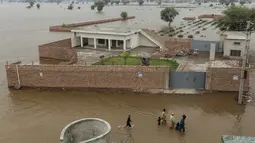Warga desa yang terdampak banjir dengan perahu di Jalalpur Pirwala, distrik Multan, provinsi Punjab, pada 8 September 2025 menyusul luapan Sungai Chenab akibat hujan muson yang deras. (Shahid Saeed MIRZA/AFP)