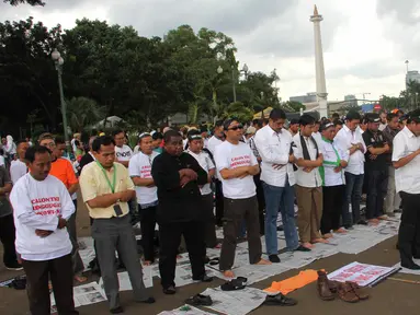 Massa dari Aliansi TKI Menggugat melakukan aksi unjuk rasa dengan cara salat di depan Istana Negara, Jakarta, Selasa (7/4/2015). Mereka menuntut Presiden Jokowi mencabut moratorium larangan pengiriman TKI ke Timur Tengah. (Liputan6.com/Helmi Afandi)