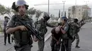 Polisi perbatasan Israel menahan seorang pengunjuk rasa Palestina dalam bentrokan di Shuafat, sebuah daerah pinggiran Arab, Yerusalem, Senin (5/10/2015). Seorang remaja Palestina tewas pada Senin dalam bentrokan di Tepi Barat. (REUTERS/Ammar Awad)