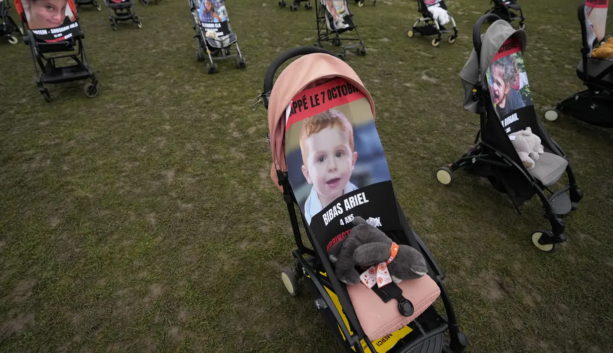 Sehari sebelumnya, boneka beruang yang ditutup matanya dengan foto anak-anak yang diculik diletakkan di depan air mancur di Tel Aviv. (AP Photo/Themba Hadebe)