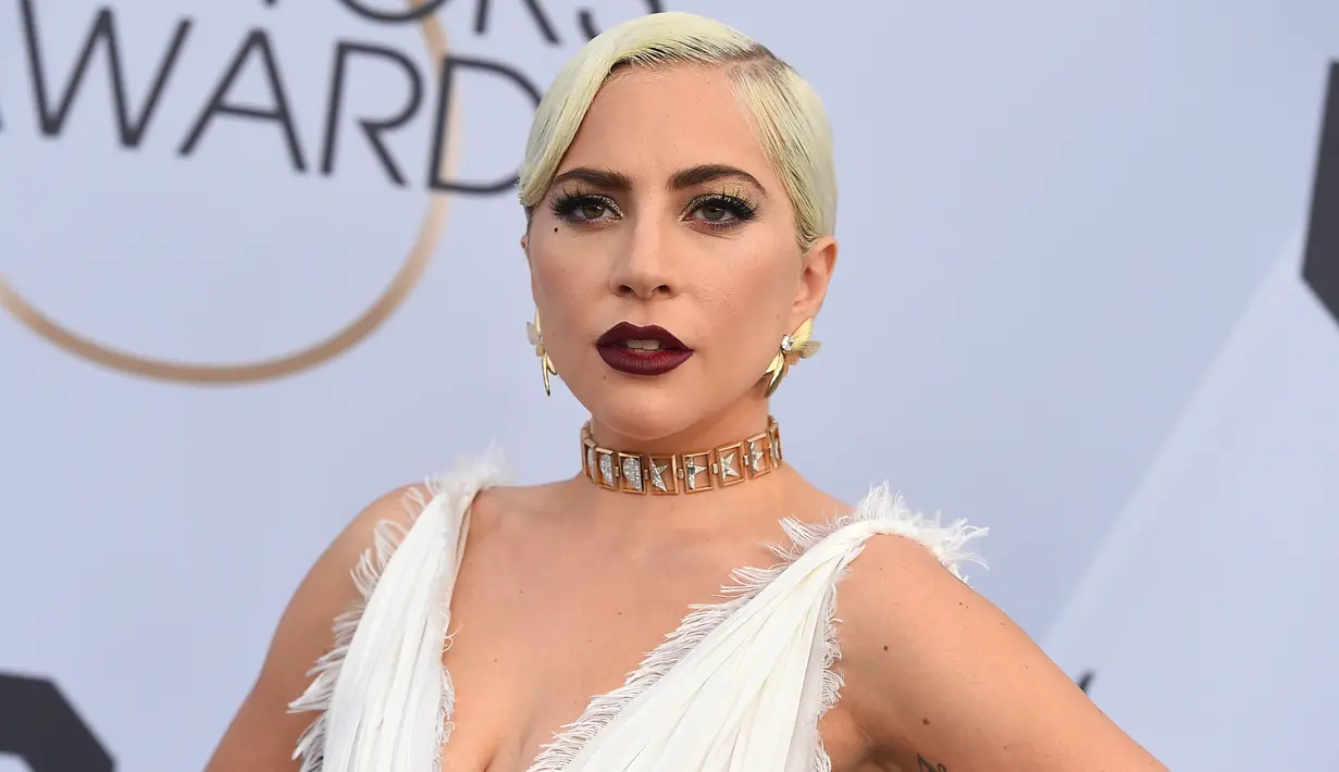 Lady Gaga berpose saat menghadiri acara 25th Screen Actors Guild Awards di Los Angeles, California, AS (28/1). Lady Gaga tampil anggun menggenakan gaun putih dengan belahan hingga paha kreasi Dior Haute Couture. (AP Photo/Jordan Strauss)