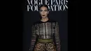 Ibu dari North West itu mengenakan rok pensil bermotif macan tutul dengan ikat pinggang hijau yang dipadukan dengan baju lengan panjang hitam dan emas saat hadir dalam sebuah acara di Paris Fashion Week 2014, Rabu (9/7/14). (AFP PHOTO/Thomas Samson)