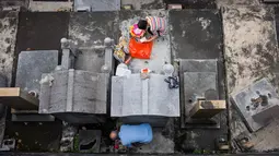 Warga membersihkan makam kerabat saat Festival Chung Yeung atau Tomb Sweeping Day di sebuah pemakaman di Hong Kong, 17 Oktober 2018. Pada saat perayaan, warga keturunan China mengunjungi dan membersihkan makam-makam leluhur mereka. (Anthony WALLACE/AFP)