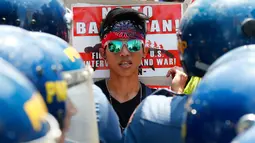 Ekspresi seorang demonstran saat menggelar aksi di Manila, Filipina (17/5). Mereka melakukan aksinya untuk memprotes latihan militer Filipina-AS yang sedang berlangsung.  (AP Photo/Bullit Marquez)