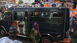 Sebuah mobil van berhiaskan trofi Piala Afrika melewati salah satu pasar di Abidjan, pusat kota Pantai Gading menjelang Piala Afrika 2023 pada Sabtu (06/01/2024) waktu setempat.. (AFP/Issouf Sanogo)