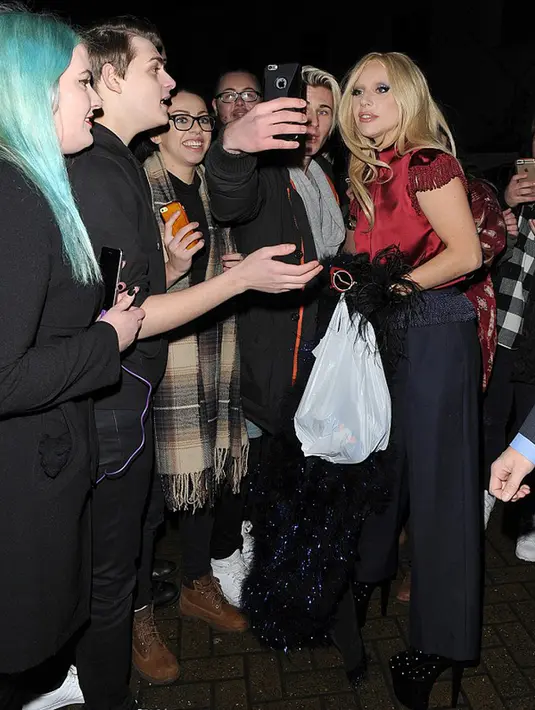 Lady Gaga saat diajak selfie seorang fans usai membeli 4 kaleng bir di sebuah toko di London, Inggris. (Dailymail)