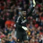 Kiper Manchester United Andre Onana melambai kepada para penggemar selama pertandingan Liga Inggris melawan Wolverhampton Wanderers di Old Trafford, Selasa (15/8/2023). MU menang 1-0 lewat gol Raphael Varane. (Lindsey Parnaby / AFP)