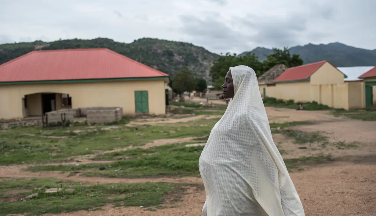 Seorang wanita berjalan di Gwoza, Nigeria timur laut, (1/8). Meskipun direbut kembali oleh pasukan Nigeria pada 2015, para ekstremis terus menyerang desa-desa terdekat di sepanjang perbatasan dengan Kamerun. (AFP Photo/Stefan Heunis)