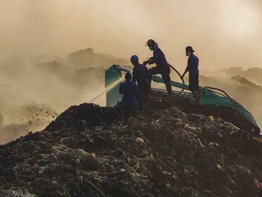 Petugas pemadam kebakaran berusaha memadamkan api di Tempat Pembuangan Akhir (TPA) Jatiwaringin, Kabupaten Tangerang, Banten, Jumat (03/07/2026). (Merdeka.com/ Arie Basuki)