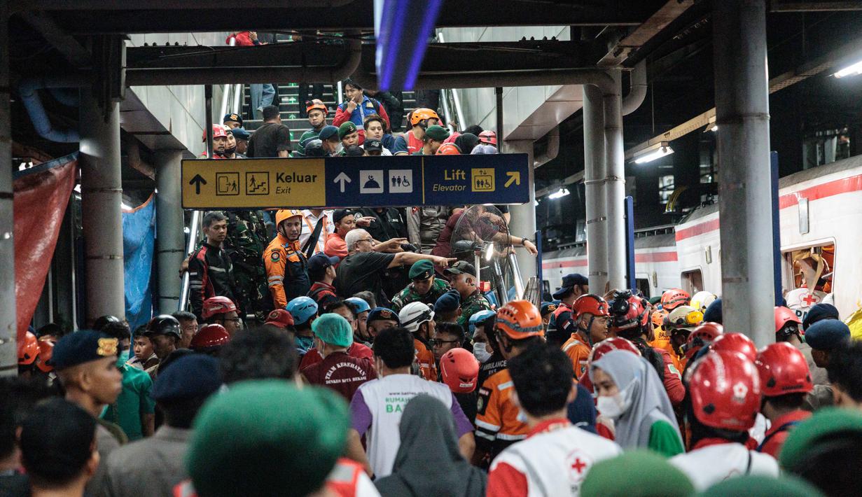 Para petugas penyelamat berupaya menyelamatkan salah satu korban yang terjebak di dalam gerbong setelah lokomotif Kereta Api Jarak Jauh (KAJJ) Argo Bromo Anggrek menabrak gerbong belakang Kereta Rel Listrik (KRL) Commuter Line di stasiun Bekasi Timur, Bekasi, Jawa Barat pada Selasa 28 April 2026. (Yasuyoshi Chiba/AFP)