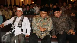 Ketua Umum PBNU, Said Aqil Siradj (tengah) bersama Ketua Dewan Komisioner Otoritas Jasa Keuangan (OJK) Muliaman D. Hadad (kanan) berbincang saat  penandatangan kerja sama di Gedung PBNU Jakarta, Senin (29/2). (Liputan6.com/Angga Yuniar)