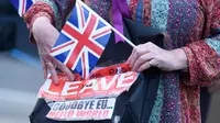 Pendukung Brexit memegang poster dan bendera Inggris di Westminster, London, Kamis (23/6). Perhitungan suara hasil Referendum Brexit menunjukkan mayoritas rakyat Inggris memilih “Brexit” alias keluar dari Uni Eropa. (REUTERS/Toby Melville)