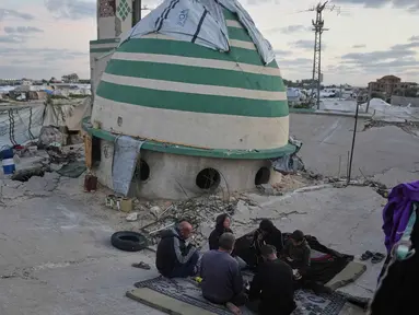 Keluarga Suleiman berbuka puasa di bulan suci Ramadan di samping reruntuhan masjid, tempat mereka saat ini berlindung di Deir al-Balah, Jalur Gaza, Jumat 6 Maret 2026. Di tengah kesulitan, keluarga Suleiman di Deir al-Balah, Jalur Gaza, berkumpul untuk menikmati momen berbuka puasa bersama. (AP Photo/Abdel Kareem Hana)