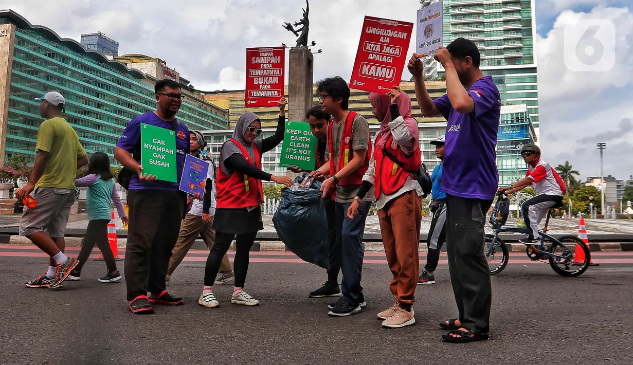 Relawan 'Operasi Semut' dari berbagai komunitas mengajak para pengunjung CFD untuk memungut sampah di Kawasan Bundaran HI, Jakarta, Minggu (19/2/2023). Aksi memungut sampah tersebut merupakan kampanye memperingati 'Hari Peduli Sampah Nasional dan Hari Bersih Indonesia 2023'. (Liputan6.com/Angga Yuniar)