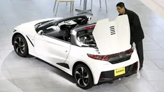 Pria melihat mobil Honda S660 di markas besar Honda Motor Co di Tokyo, Jepang, (24/2). Setelah hampir setahun pengerjaan, CEO Honda Motor Co Takahiro Hachigo berencana memperkenalkan mobil Honda S660 ke Publik. (REUTERS/Thomas Peter)