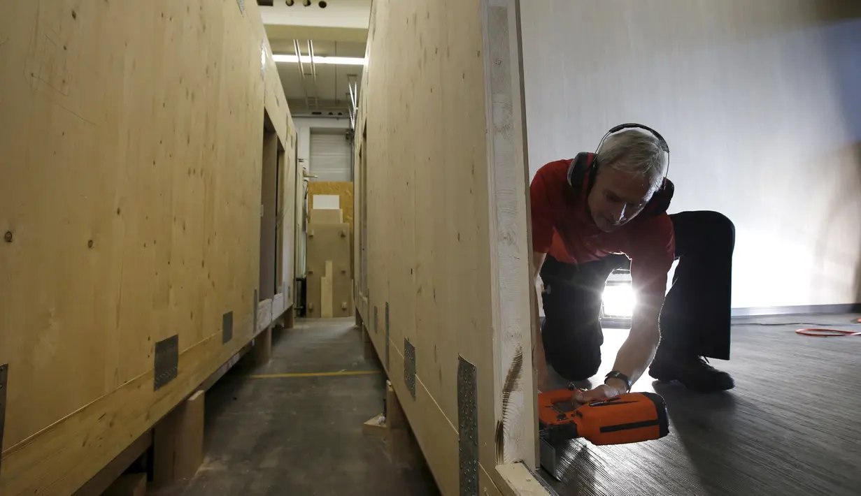 Pegawai bangunan saat membenarkan bangunan rumah prefabrikasi di perusahaan konstruksi Bauer Holzsysteme, Jerman, (7/12).   Komponen Struktur Prefabrikasi dibuat dari beton. (REUTERS/Michaela Rehle)