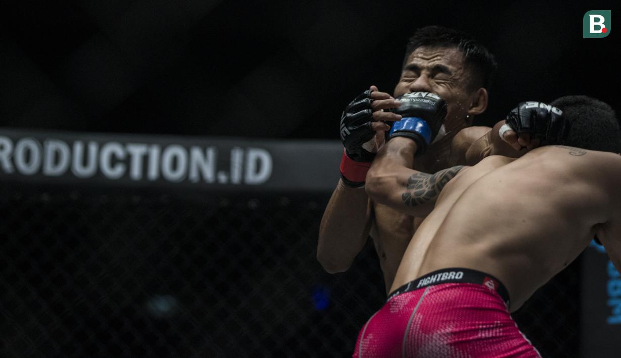 Atlet MMA Indonesia, Stefer Rahardian, terkena pukulan atlet MMA China, Peng Xue Wen, pada kelas strawweight di JCC Senayan, Jakarta, Sabtu (22/9/2018). Stefer Rahardian kalah dari Peng Xue Wen. (Bola.com/Vitalis Yogi Trisna)