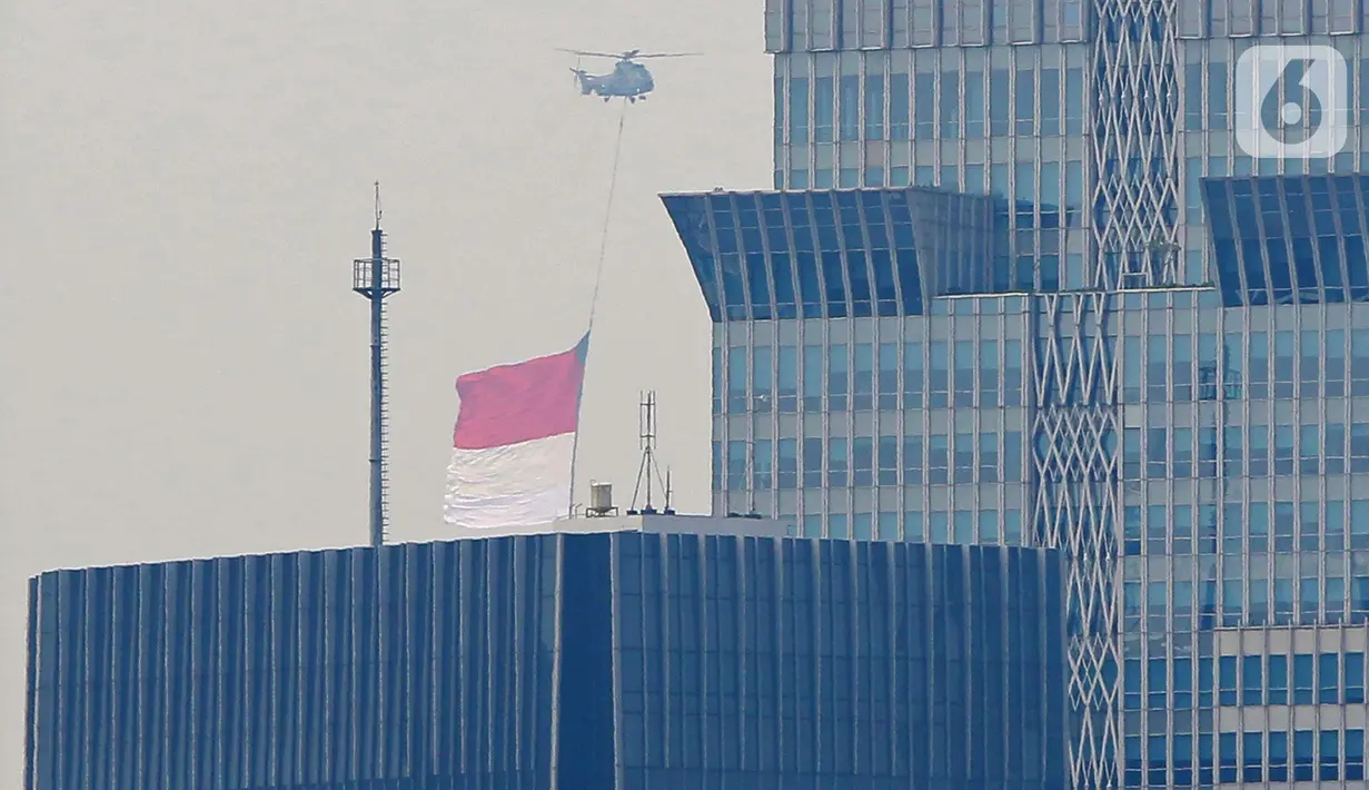 Helikopter TNI AU mengibarkan bendera merah putih raksasa di langit Jakarta, Jumat (13/8) untuk persiapan puncak peringatan HUT ke-76 RI (Foto: Liputan6.com/Herman Zakharia)