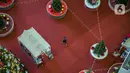 Pengunjung melintas di dekat Pohon Natal Raksasa  di Mall Taman Anggrek, Jakarta, Senin (21/12/2020). Mal ini juga memasang pohon Natal megah dikelilingi beberapa pohon cemara asli dihiasi bola-bola kecil berwarna merah dan silver. (Liputan6.com/Faizal Fanani)