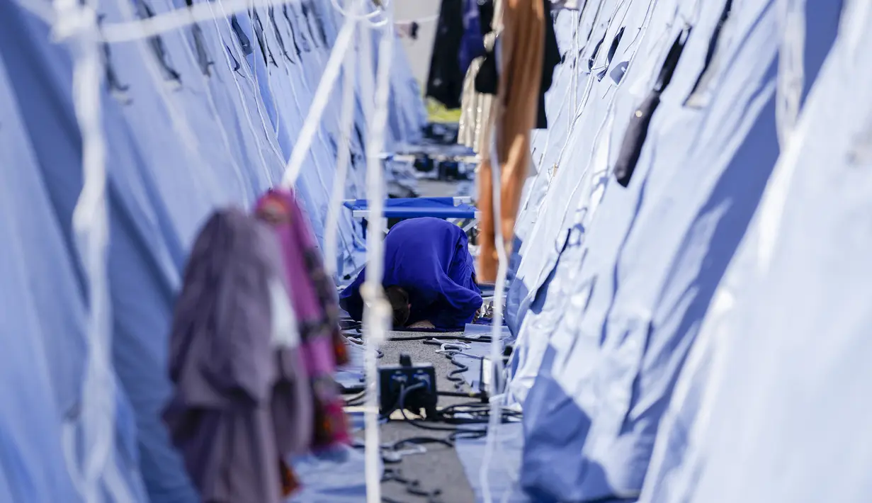 Seorang pengungsi Afghanistan melaksanakan salat di kamp pengungsian Palang Merah Italia, Avezzano, Italia, Selasa (31/8/2021). Kamp karantina ini menampung 1.250 imigran. (AP Photo/Andrew Medichini)