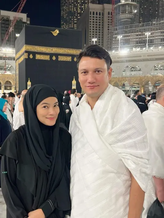 Berpose dengan sang suami di depan ka’bah, Titi Kamal terlihat mengenakan gamis hitam yang dipadukan pashmina instan warna senada. [@titi_kamall]