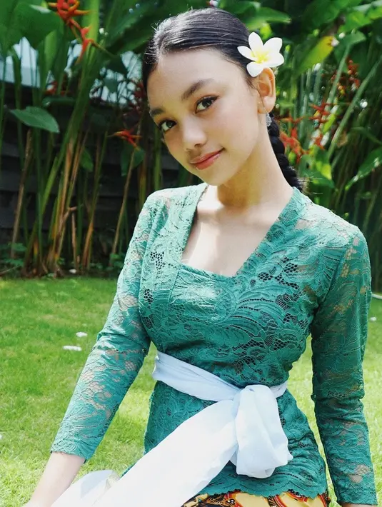 Naura memakai kebaya berpotongan kutu baru dengan selendang yang diikat menjadi obi ala gadis Bali serta menyematkan bunga di telinganya (Foto: Instagram @naura.ayu)