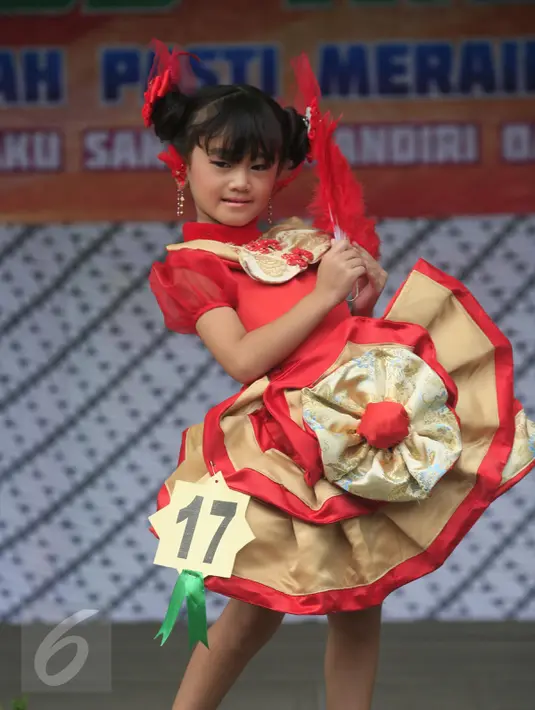 Salah satu peserta berpose memperagakan busana cheongsam saat mengikuti fashion show di SD Warga, Solo, Jawa Tengah, Jumat (5/2/2016). Fashion show bernuansa tionghoa diselenggarakan untuk menyambut Tahun Baru Imlek. (Foto: Boy Harjanto)
