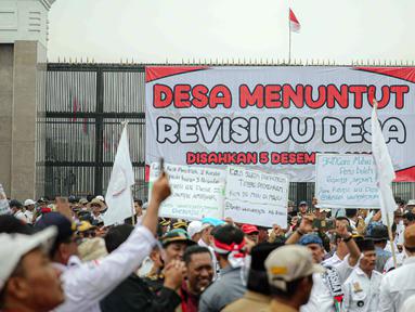 Sejumlah perangkat desa yang tergabung dalam Persatuan Perangkat Desa Indonesia (PPDI) berunjuk rasa di depan Gedung DPR, Jakarta, Kamis (23/7/2023). Dalam aksinya, mereka mendesak DPR dan pemerintah untuk merevisi UU No. 6 Tahun 2014 tentang Desa. (Liputan6.com/Faizal Fanani)
