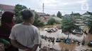 Warga melihat kondisi banjir yang merendam permukiman Cipinang Melayu, Jakarta, Rabu (1/1/2020). Ratusan rumah warga di Kelurahan Cipinang Melayu terendam banjir hingga ketinggian leher orang dewasa sejak dini hari tadi dan telah menewaskan dua warga. (merdeka.com/Iqbal S Nugroho)