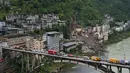 Kendaraan penyelamat bersiaga di jembatan saat tim penyelamat melakukan operasi pencarian dan penyelamatan di lokasi tanah longsor di Kabupaten Pengshui, Chongqing, Tiongkok barat daya, Sabtu, 18 Juli 2026. (AP Photo/Andy Wong)
