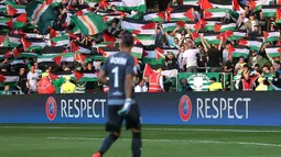 Bendera Palestina dikibarkan oleh suporter Celtic saat melawan Hapoel Beer Sheva di kualifikasi Liga Champions di Celtic park, (19/8).  Aksi dilakukan sebagai bentuk kecaman terhadap invasi Israel yang terjajah hingga saat ini. (REUTERS/Russell Cheyne)
