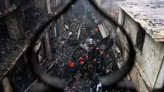 Petugas pemadam kebakaran terlihat di lokasi kebakaran di Dhaka (21/2). Setidaknya 69 orang tewas dalam kebakaran besar yang melanda gedung apartemen yang juga digunakan sebagai gudang bahan kimia di Bangladesh tersebut. (AFP Photo/Munir Uz Zaman)