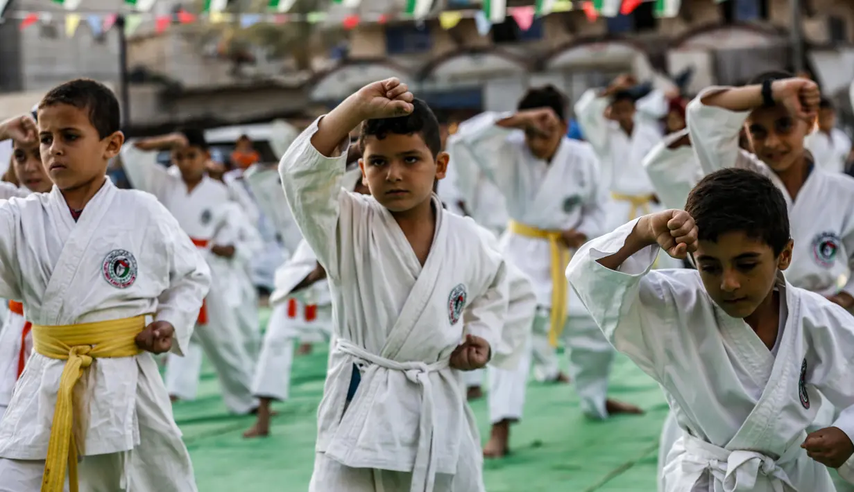 Anak-anak Palestina menunjukkan keterampilannya selama upacara promosi Karate di sebuah pusat olahraga di kamp Rafah untuk pengungsi Palestina di Jalur Gaza selatan (20/9/2019). (AFP Photo/Said Khatib)