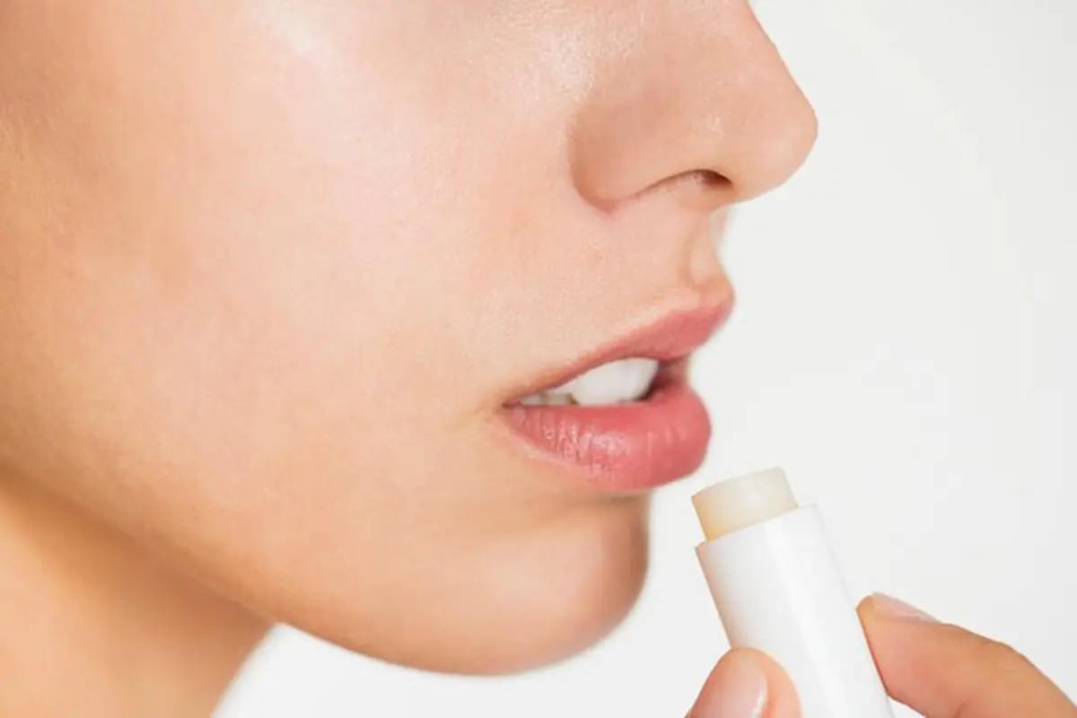 Seorang perempuan menggunakan produk lip balm untuk merawat bibirnya (Foto Dok: Freepik/rawpixel.com)