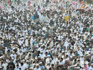 Umat muslim mendengarkan khutbah usai melaksanakan salat Idul Fitri 1438 H di jalanan kawasan Jatinegara, Jakarta, Minggu (25/7). Ruas Jalan Jatinegara Barat disulap menjadi tempat pelaksanaan salat Ied. (Liputan6.com/Yoppy Renato)