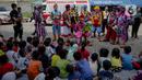 Anak-anak menyaksikan aksi badut yang tergabung dalam komunitas Aku Badut Indonesia (ABI) di pengungsian korban banjir di Gor Pangadegan, Jakarta, Selasa (7/1/2020). Trauma healing diberikan para badut sebagai bentuk kepedulian terhadap anak-anak korban banjir Jakarta. (Liputan6.com/Faizal Fanani)