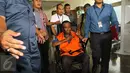 Tersangka dugaan korupsi proyek e-KTP, Sugiharto menggunakan kursi roda keluar dari Gedung KPK, Jakarta, Rabu (19/10). Setelah menjalani pemeriksaan sekitar 4 jam, Sugiharto keluar dengan memakai rompi tahanan berwarna oranye. (Liputan6.com/Helmi Afandi)