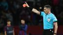 Wasit Istvan Kovacs memberikan kartu merah kepada Pelatih Barcelona, Xavi, saat melawan Paris Saint-Germain pada duel leg kedua perempat final Liga Champions 2023/2024 Stadion Olimpic Lluis Companys, Rabu (17/4/2024). (AFP/Franck Fife)
