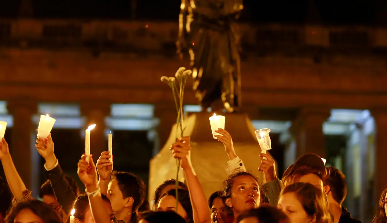 Ratusan orang pendukung kesepakatan damai membawa lilin ketika menggelar aksi diam di Bolivar Square, Bogota, Rabu (5/10). Kesepakatan damai ini ternyata tidak berjalan baik, lantaran 50,5 persen rakyat Kolombia menolak perdamaian. (REUTERS/John Vizcaino)