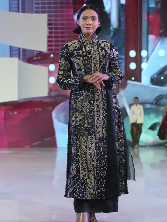 Andini Effendi mengenakan kebaya panjang yang didekonstruksi dengan lengan yang dapat dilepas. Gaya multi-arah dengan kancing pinggang tersembunyi di samping Manipulasi tenun tanpa jahitan yang dibuat dengan motif yang dijahit tangan menggunakan benang sutra. Kombinasi kain Silk Duchess dan Sutra Tenun Karan-gasem. [Adrian/Fimela]