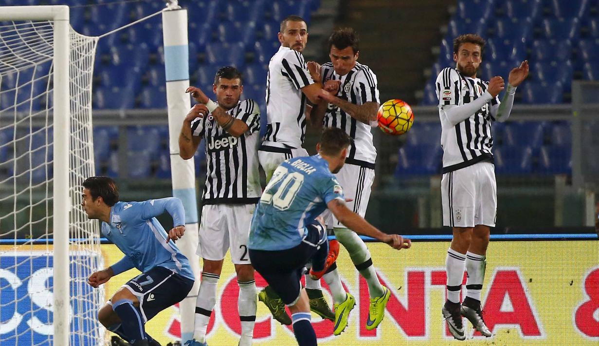 Pemain Lazio,  Lucas Biglia  melakukan tembakan bebas saat dihadang para pemain Juventus pada lanjutan Liga Italia Serie A di Stadion Olimpico, Sabtu (5/12/2015) dini hari WIB. (REUTERS/Tony Gentile)