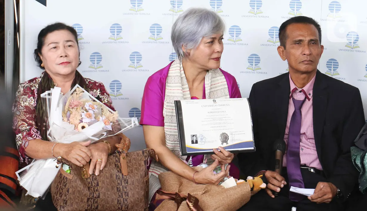 Ayah Brigadir Nofriansyah Yosua Hutabarat atau Brigadir J, Samuel Hutabarat (kanan) didampingi Ketua Komunitas Civil Society Indonesia Irma Hutabarat (tengah) saat mewakili anaknya mengikuti prosesi wisuda di Universitas Terbuka, Pamulang, Tangerang Selatan, Banten, Selasa (23/8/2022). Brigadir J lulus memuaskan dengan IPK 3,28. (Liputan6.com/Herman Zakharia)