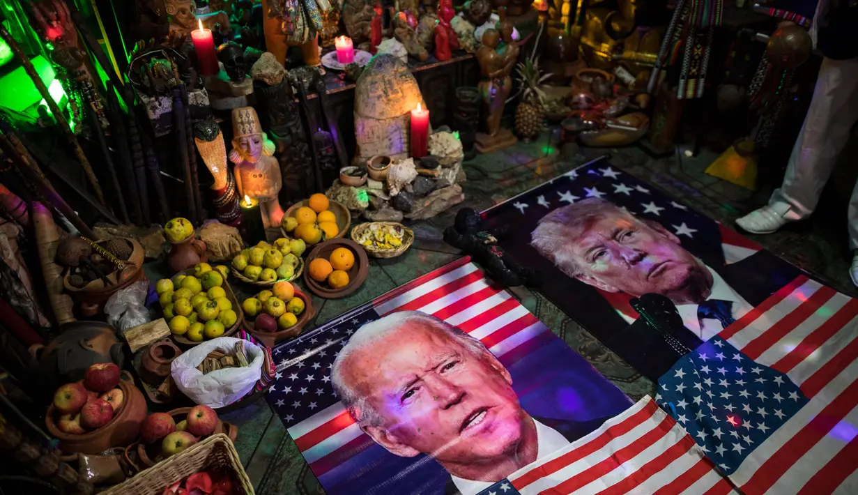 Gambar Presiden Donald Trump dan pesaingnya dari Demokrat Joe Biden, tergeletak di altar selama upacara, di dalam apartemen di Lima, Rabu (16/9/2020). Dukun Peru berkumpul untuk memprediksi siapa pemenang dari pemilihan presiden AS yang akan dihelat pada 3 November mendatang. (AP Photo/Rodrigo Abd)