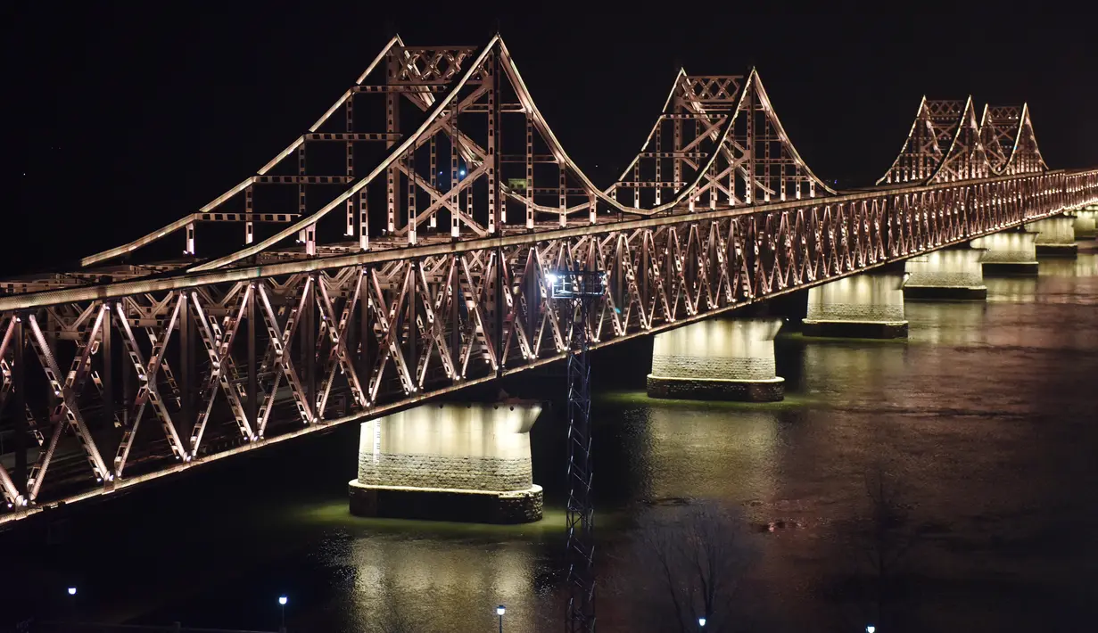 Suasana  Jembatan Persahabatan saat malam terlihat dari kota Dandong di provinsi Liaoning, China (22/2). Pemimpin Korut Kim Jong Un diperkirakan akan melintasi jembatan ini untuk melakukan pertemuan dengan Presiden AS Donald Trump. (AFP Photo/Greg Baker)