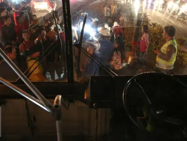 Sejumlah warga mengerumuni pria tanpa identitas yang sekarat usai di tabrak bus PPD 213 di kawasan Matraman Raya, Jakarta, Kamis (20/8/2015). Menurut saksi pria tersebut nekat menyeberang melewati jalur busway. (Liputan6.com/Faizal Fanani)