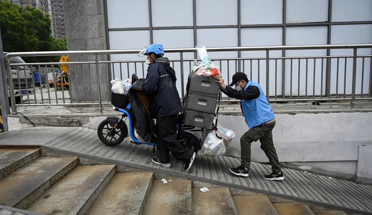 <p>Pengemudi pengiriman untuk supermarket Hema Fresh Alibaba mendorong skuter dengan pesanan makanan di Beijing, China, Selasa (10/5/2022). Jutaan orang di Beijing tinggal di rumah pada 9 Mei ketika Ibu Kota China tersebut mencoba untuk menangkis wabah COVID-19 dengan pembatasan pergerakan. (Jade GAO/AFP)</p>