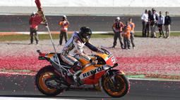 Marc Marquez melakukan selebrasi dengan mengitari track pada balapan MotoGP Valencia di Ricardo Tormo Circuit, Cheste, (12/11/2017). Gelar tersebut merupakan yang keempat buat Marquez.  (AFP/Jose Jordan)