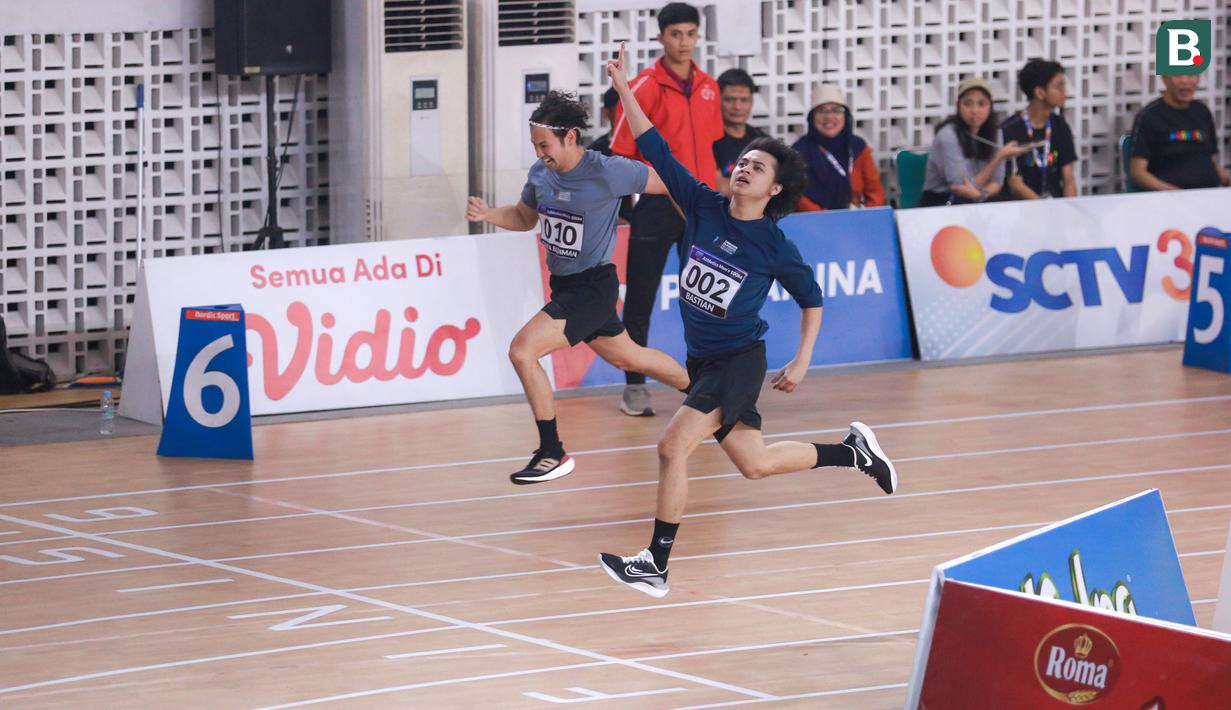 Selebritas Indonesia, Bastian Steel (kanan) melakukan selebrasi di samping Tarra Budiman menjelang garis finis lari 100 meter putra Turnamen Olahraga Selebriti Indonesia (TOSI) di GOR UNJ, Rawamangun, Jakarta, Minggu (30/07/2023). Bastian sukses finis tercetap dengan catatan waktu 16,32 detik. (Bola.com/Bagaskara Lazuardi)