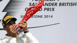 Selebrasi pembalap Formula Satu dari tim Mercedes, Lewis Hamilton, usai memenangi GP Inggris yang dihelat di Sirkuit Silverstone, (6/7/2014). (REUTERS/Francois Lenoir)